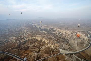 Wall Mural - Colorful hot air balloon ride and tour in Goreme valley, semi-arid region in central Turkey known for its distinctive fairy chimneys, tall, cone-shaped rock formation- Cappadocia, Turkey