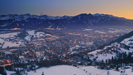 Wall Mural - Dusk over zakopane city in winter at night, aerial view