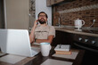 © Seleznov_Molchanova - Smiling handsome freelancer working remotely from home. He is speaking on the phone.