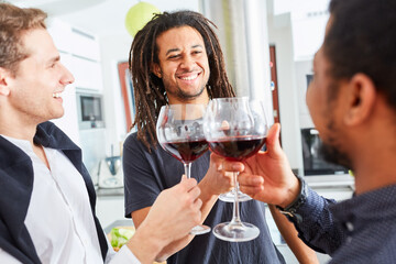 Afrikaner mit Dreadlocks stößt mit Männern mit Glas Wein an