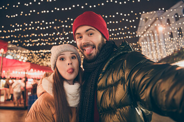 Sticker - Photo of two funny people friends make selfie show tongue under x-mas christmas outdoors evening lights