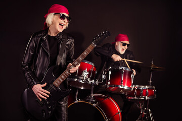 Canvas Print - Photo of two aged pensioner lady man rock group perform concert play drum instruments solo guitar hobby bring money wear trendy rocker leather outfit bandana isolated black color background