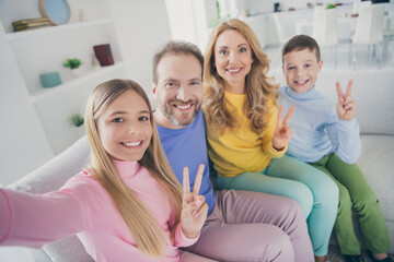 Poster - Photo of positive people family sit couch mom dad two little kids make v-sign take selfie in house indoors