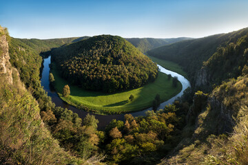 Wall Mural - Thaya river during summer or autumn time. Sunny day in the Thayatal Valley, National park, Lower Austria. Top view of the river with turns of meanders and green forests in bright sunlight. Nature 