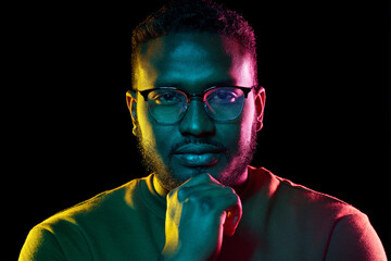 people and ethnicity concept - portrait of young african american man in glasses over black backgrou