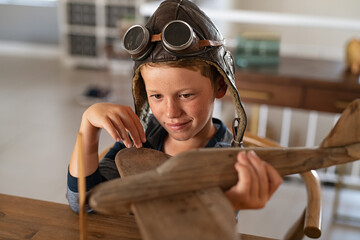 Wall Mural - Child playing with wooden airplane at home