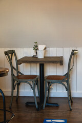 Two empty chairs at a rustic cafe table with no people