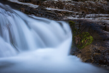 Wall Mural - River water flows among the rocks and forms small waterfalls, Rascafría, Madrid, Spain