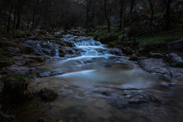 Wall Mural - River water flows among the rocks and forms small waterfalls, Rascafría, Madrid, Spain