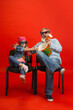 © master1305 - Popcorn time. Senior man spending happy time with granddaughter in neon. Joyful elderly lifestyle, family, childhood, tech concept. Enjoying modern cinema, movie technologies. Copyspace.
