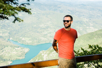 Wall Mural - Young man in the mountain enjoying the view of the lake 