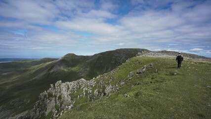 Canvas Print - Backpacking man walking  a green mountain ridge in Wales UK