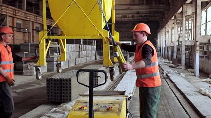 Wall Mural - Workers on the concrete plant. Plant for the creation of reinforced concrete slabs. Employees in hard hat work inside manufacturing. Heavy industry concept.