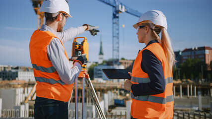 Construction Worker Using Theodolite Surveying Optical Instrument for Measuring Angles in Horizontal and Vertical Planes on Construction Site. Engineer and Architect Using Tablet Next to Surveyor.