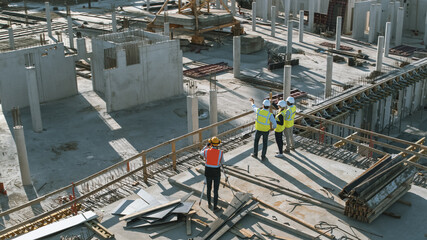 Wall Mural - Aerial Shot of a New Constructions Development Site with Diverse team of Engineers and Architects Discussing Real Estate Projects. Heavy Machinery and Construction Workers are Working in the Area.