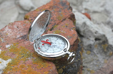 Iron compass on brick wall as symbol of tourism with compass, travel with compass and outdoor activities with compass