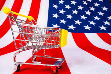 Poster - Purchases in the United States. American online store. The shopping cart is on the flag of the United States. Trade in the United States. The purchasing power of Americans.
