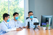 © visoot - Group of doctor wearing protective surgical mask discuss work together and looking at online presentation on computer at hospital.