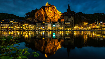 A reflection of the Walloon city of Dinant in the Belgian Ardennes. It's a long exposure picture during the blue hour, overlooking the rock with the Dinant Citadel and the Church of Dinant.