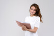 © Iryna - Young beautiful woman holds pink notebook, wearing white t-shirt, isolated over white background with copy space