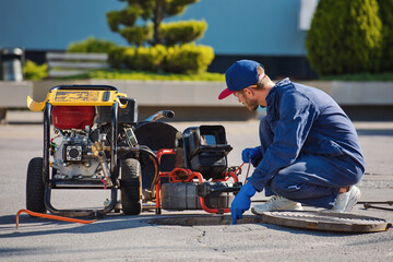 Plumber prepares to fix the problem in the sewer. Repair work on troubleshooting.