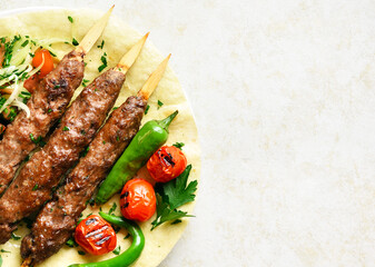 Adana Kebab with fresh vegetables on flatbread