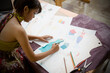 © SuperStock - Indian female fashion designer drawing