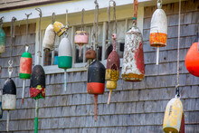 Colorful Buoys On The Side Of A Wooden Cape Style Home