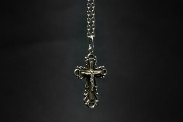 Cross with chain on a dark background.