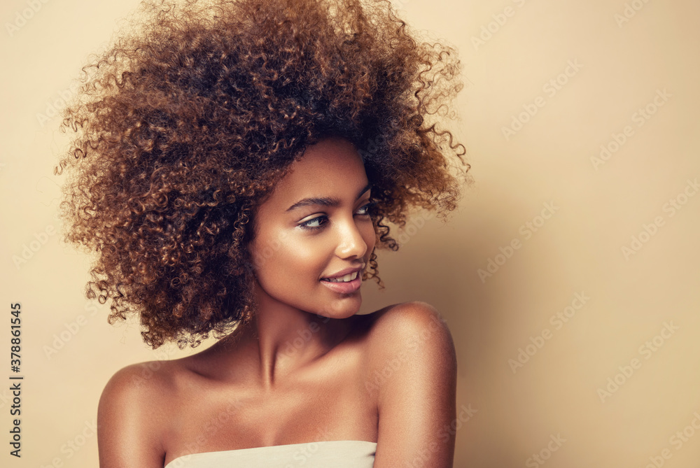 Beautiful black woman . Beauty portrait of african american woman with clean healthy skin on beige background.  Smiling beautiful afro girl.Curly black hair - obrazy, fototapety, plakaty 