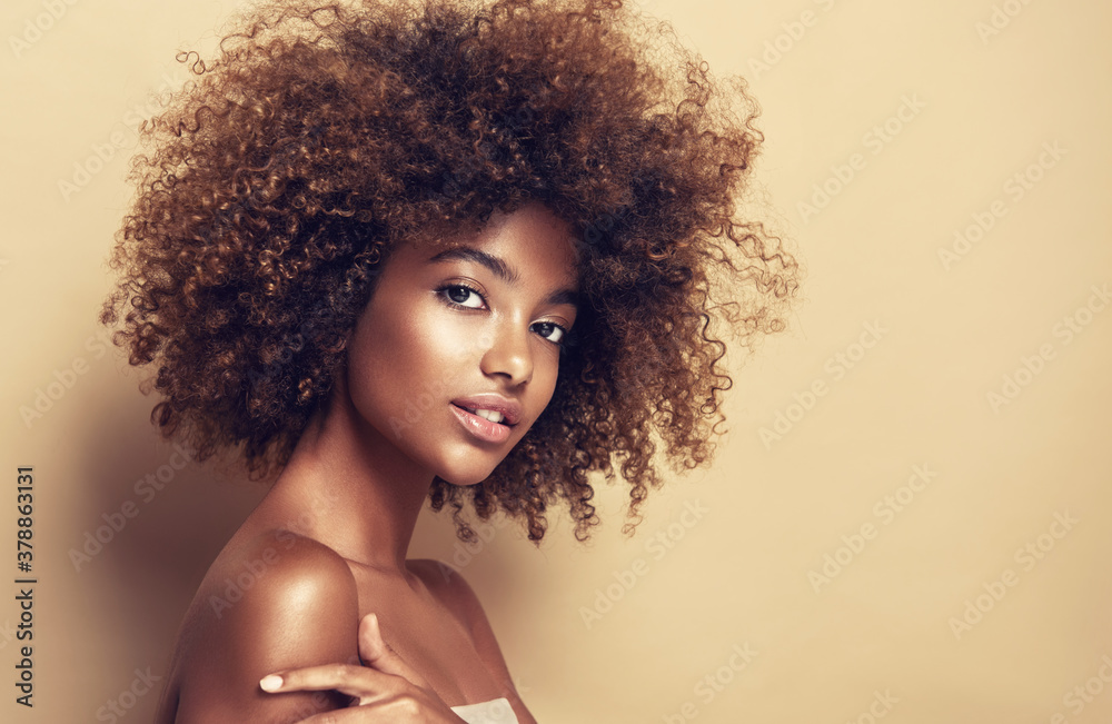 Beautiful black woman . Beauty portrait of african american woman with clean healthy skin on beige background.  Smiling beautiful afro girl.Curly black hair - obrazy, fototapety, plakaty 