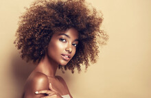 Beautiful Black Woman . Beauty Portrait Of African American Woman With Clean Healthy Skin On Beige Background.  Smiling Beautiful Afro Girl.Curly Black Hair