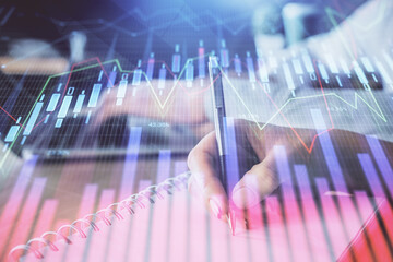 Double exposure of forex chart drawing over people taking notes background. Concept of financial analysis