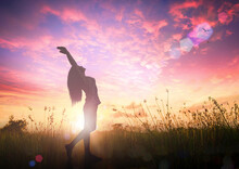 Celebration Of Life Day Concept: Silhouette Of Healthy Woman Raised Hands For Praise And Worship God At Autumn Sunset Meadow Background