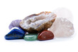 Collection of small polished gems and stones, with a quartz geode in the center.  Variety of colors and textures, with space above for copy.