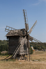 old wooden mill in a field in summer