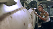 Attractive Young Woman Mechanical Worker Repairing A Vintage Car In Old Garage..