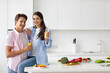 © BestForYou - Young couple in love with a glass of orange juice in the kitchen.