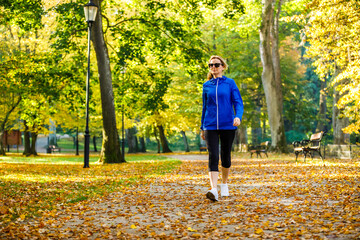 Wall Mural - middle-aged woman walking in city park