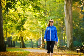 Wall Mural - middle-aged woman walking in city park