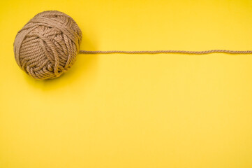 Canvas Print - High angle shot of a ball of yarn on a yellow surface