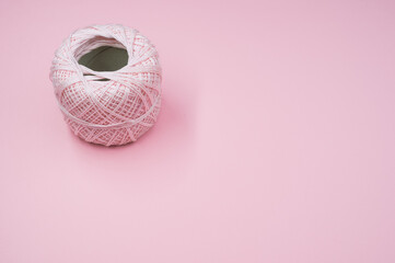 Canvas Print - High angle shot of a ball of yarn on a pink surface