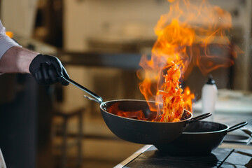 Modern kitchen. Cooks prepare meals on the stove in the kitchen of the restaurant or hotel. The fire in the kitchen.