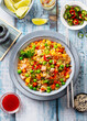Asian fried rice with vegetables and ham. Blue wooden background. Copy space. Top view.
