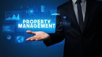 Hand of Businessman holding PROPERTY MANAGEMENT inscription, business success concept