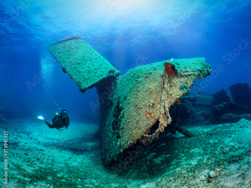 Fotomural A scuba diver explores a sunken shipwreck in shallow waters of the Aegean Sea, G