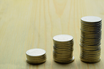 Three stacks of iron coins stand in a row on a wooden background