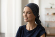 Smiling young Caucasian sick woman with scarf on head suffer from oncology look in distance dream of recovery. Happy ill female patient struggling with cancer think of remission. Healthcare concept.