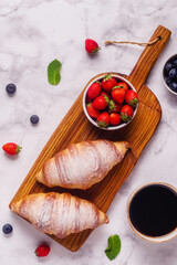 Breakfast with croissants and fresh fruits.