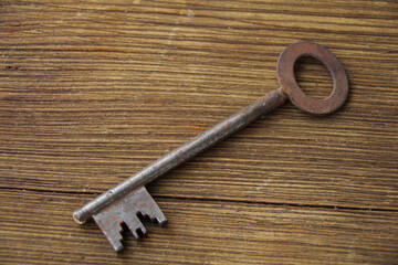 old key lies on an old wooden table, natural textures, the concept of discovery, secrets, answers, answers to difficult questions